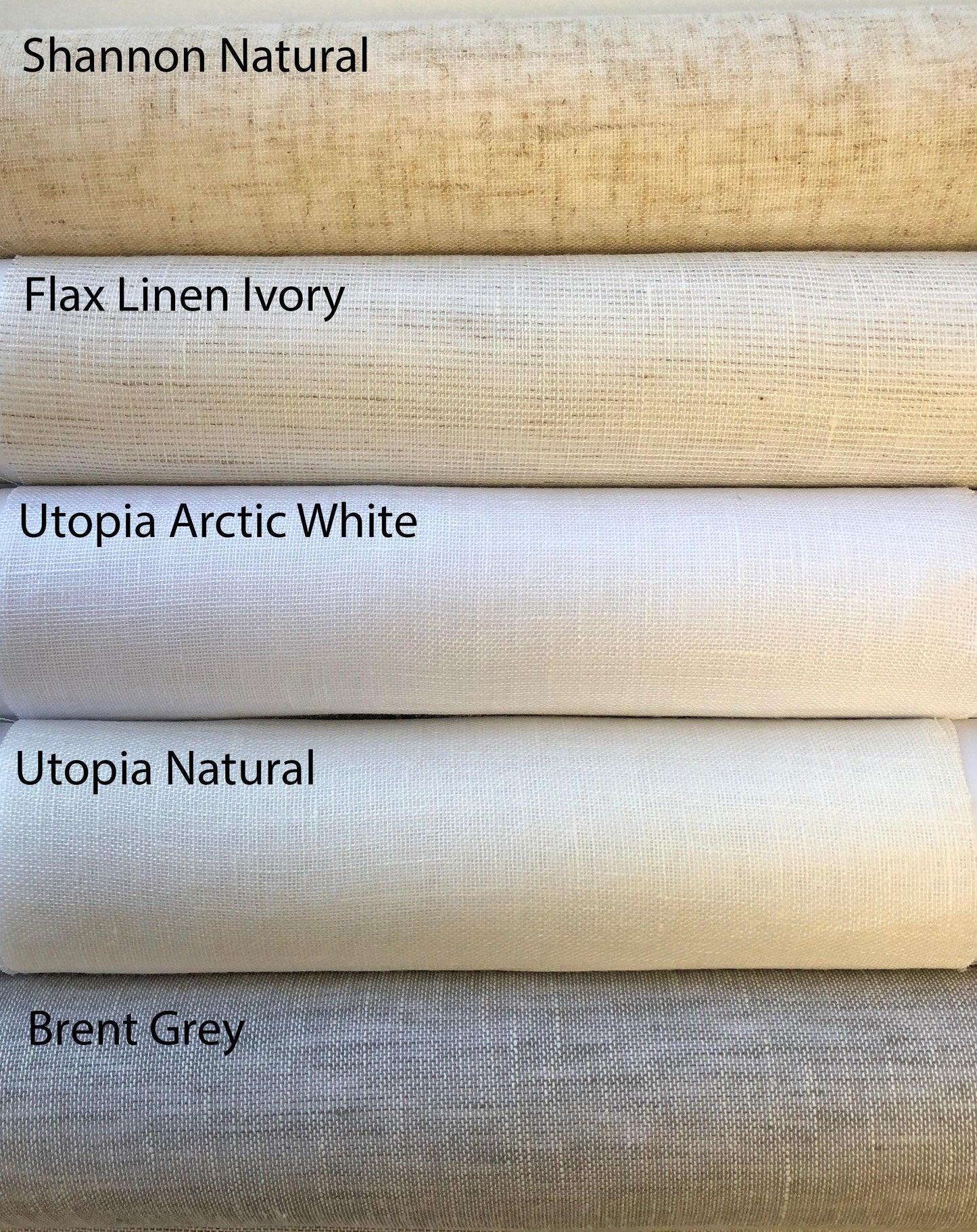 Natural linen fabric sample rolls for custom Roman shades and curtains: Shannon Natural, Flax Linen Ivory, Utopia Arctic White, Utopia Natural and Brent Grey woven fabrics.