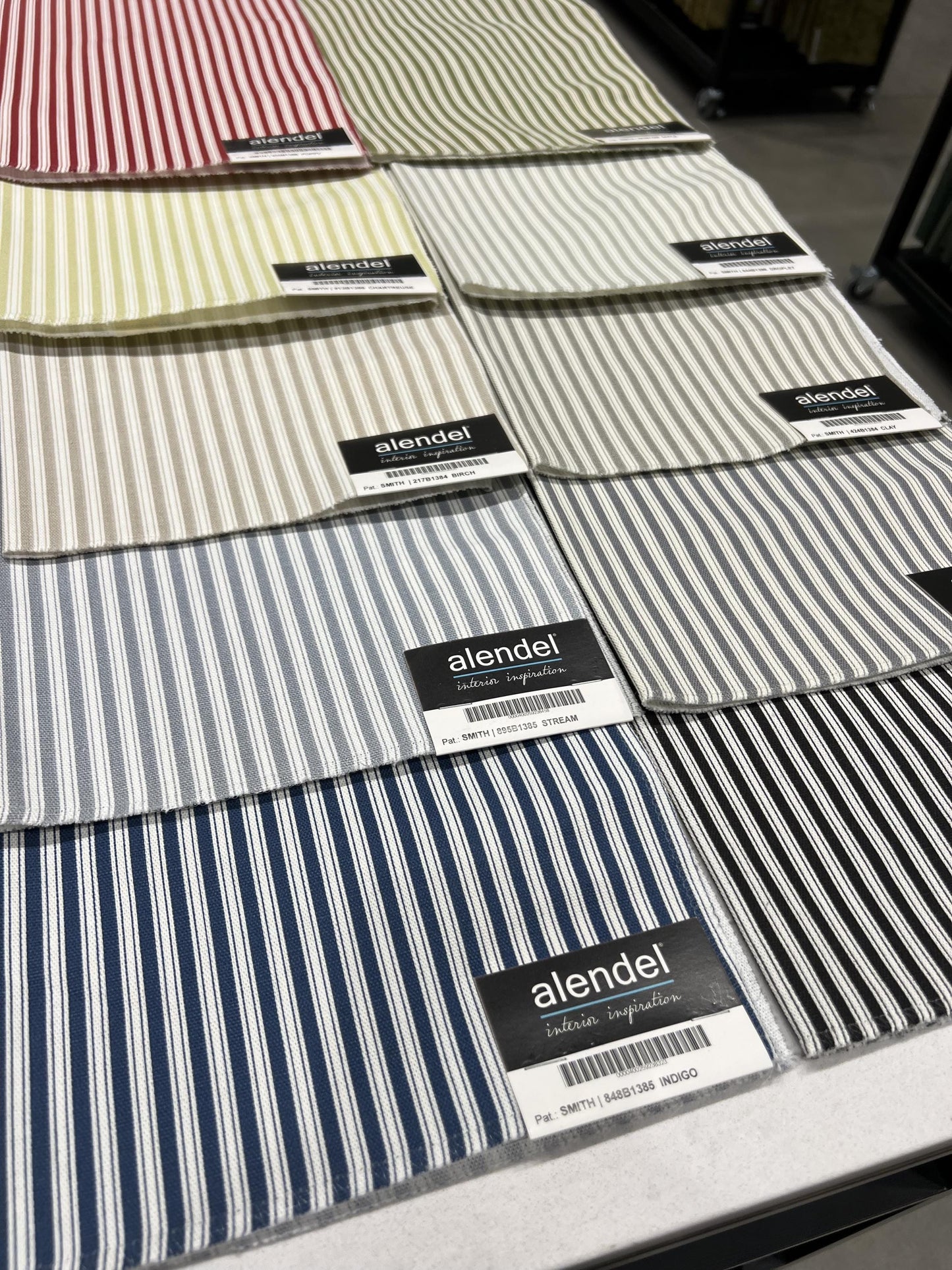 Stack of navy and grey ticking stripe cotton swatches for made to order cafe curtains.
