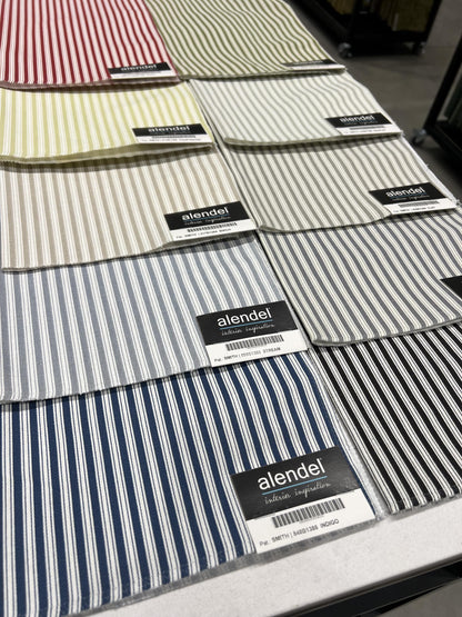 Stack of navy and grey ticking stripe cotton swatches for made to order cafe curtains.
