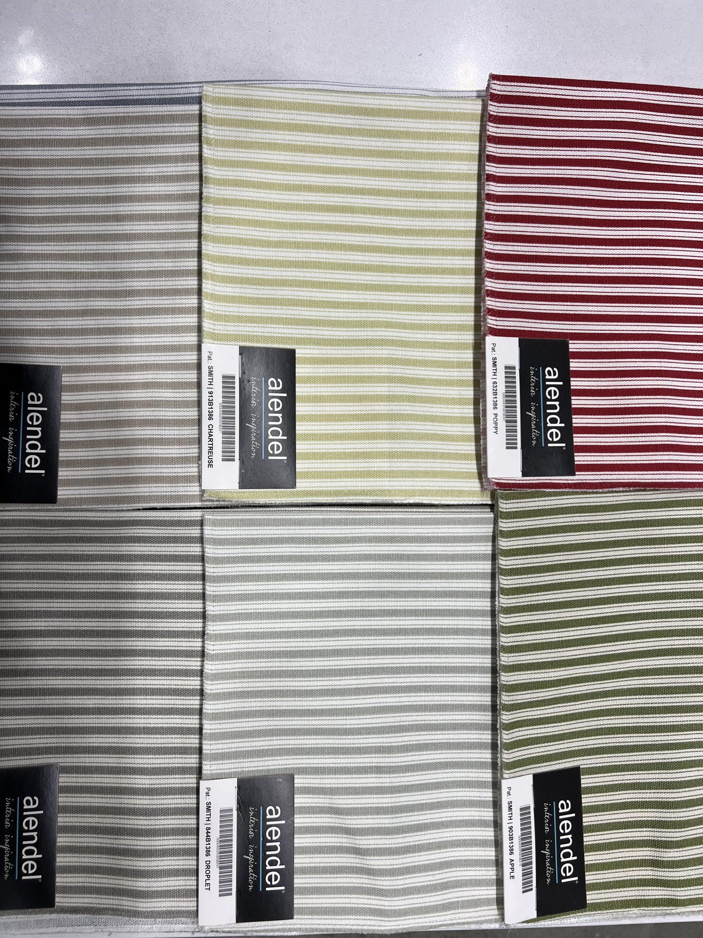Ticking stripe cotton fabric swatches in green, cream and red from the Alendel Smith range.