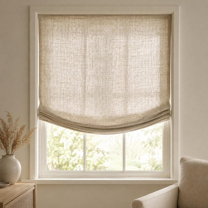 European relaxed Roman shade in Tuscany natural linen, lowered with a soft curved hem in a beige living room
