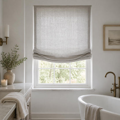 Grey linen European relaxed Roman shade in a bathroom with a freestanding tub