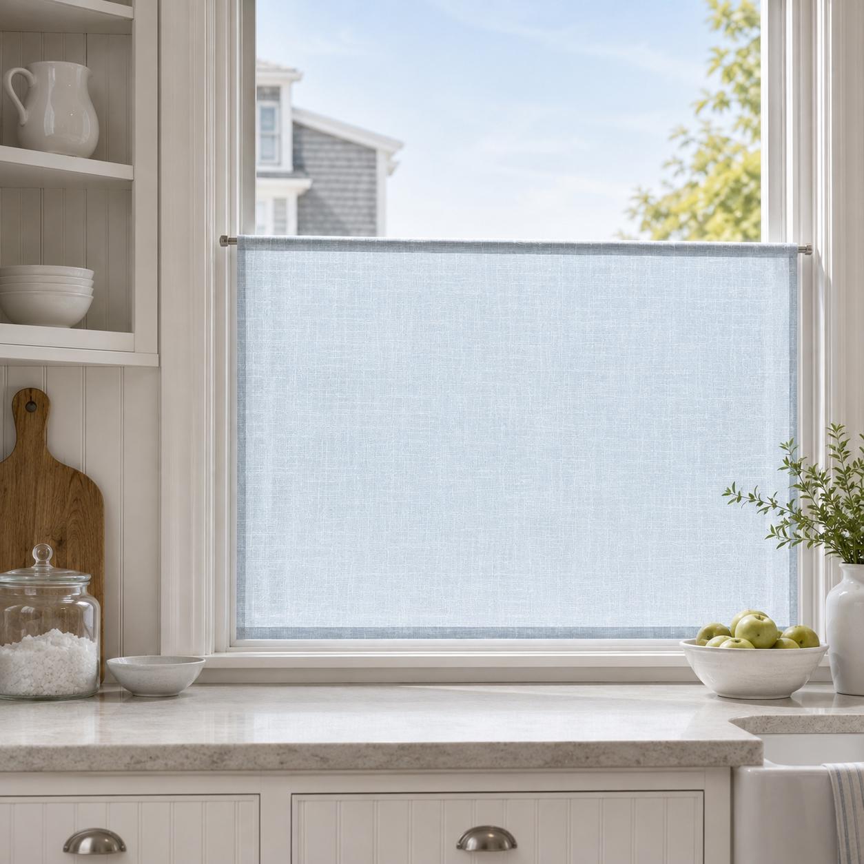 Sky blue faux linen cafe curtain on the lower half of a bright kitchen window