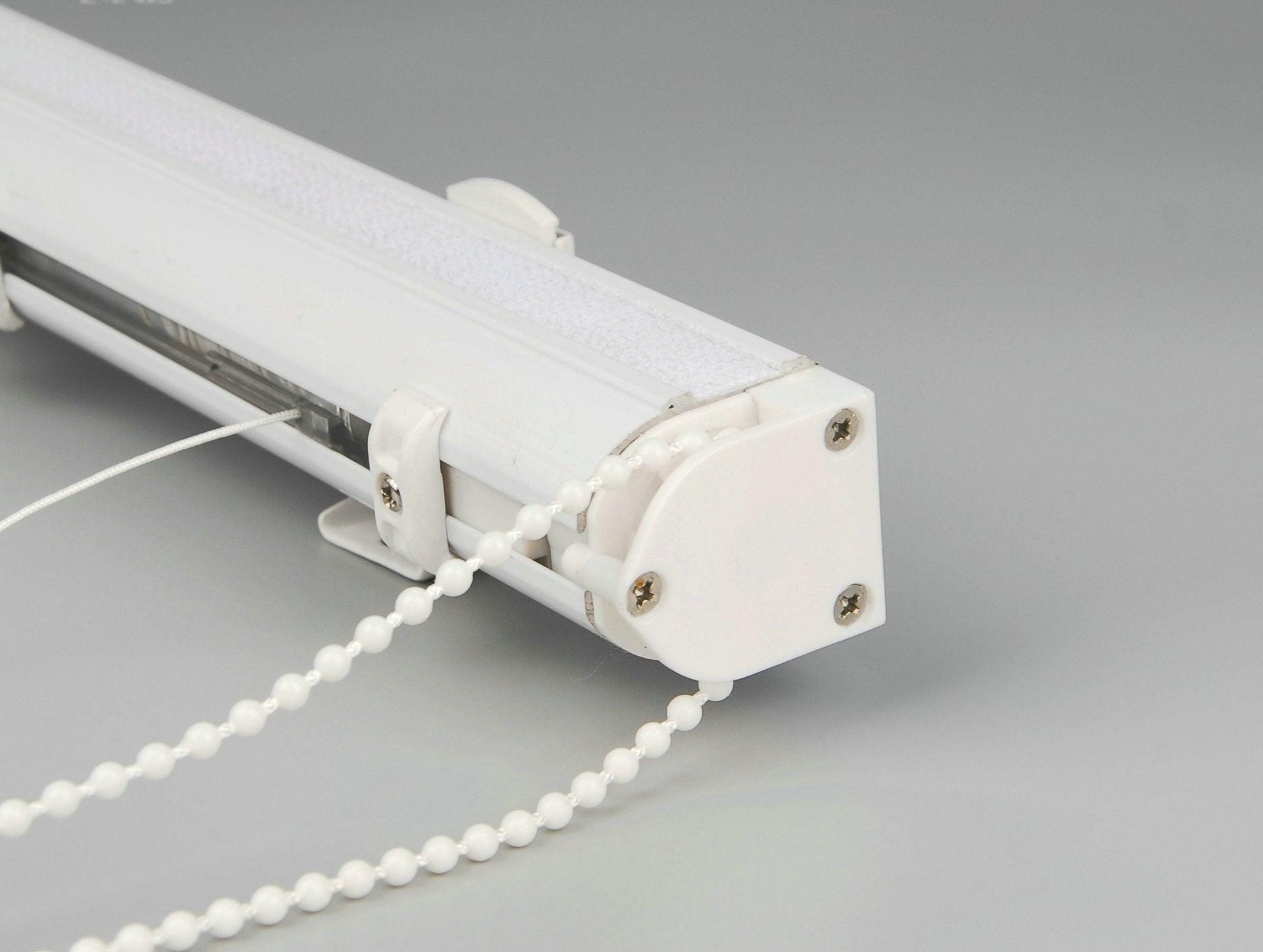 White aluminium headrail with bead chain control and mounting bracket of a custom Roman shade