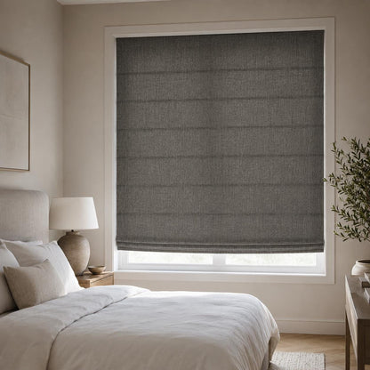 Charcoal linen Roman shade in a bedroom above the bed, fitted inside the window frame