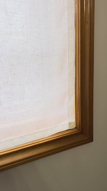 Video: sheer linen cafe curtain fitted inside a wood-framed window, daylight glowing through the open weave