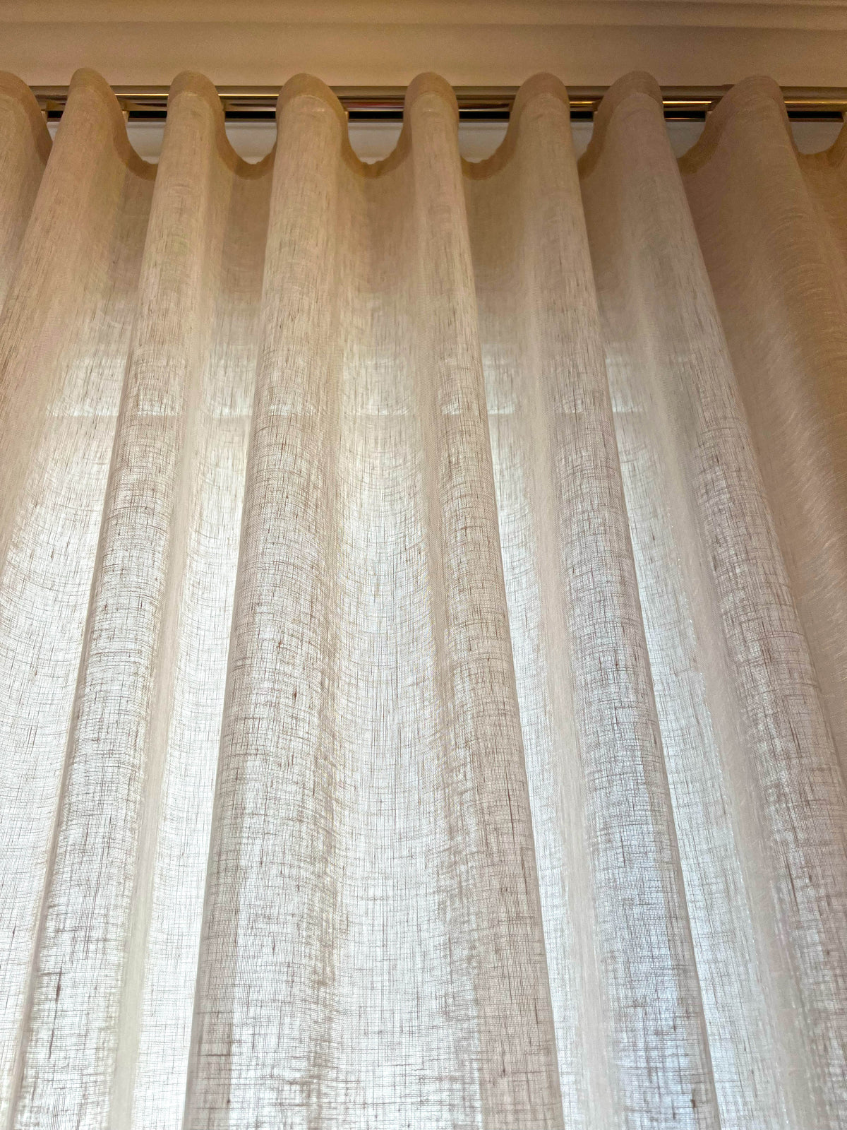 Ripple fold header of a Brent Candle linen-blend sheer, slub weave glowing with daylight behind it